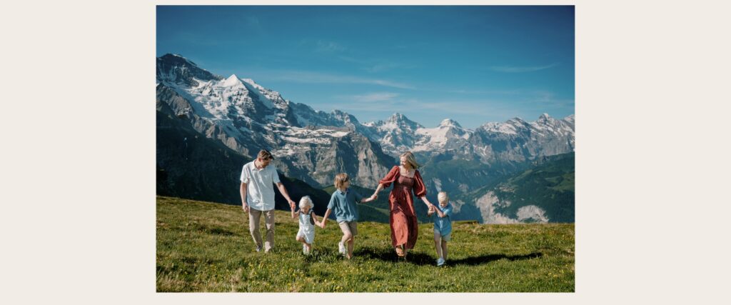 Family walking together in a mountain meadow during a Lauterbrunnen Swiss Alps photo session