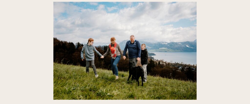 Family walking together with their dog above Lake Lucerne during a natural family photography session in Switzerland