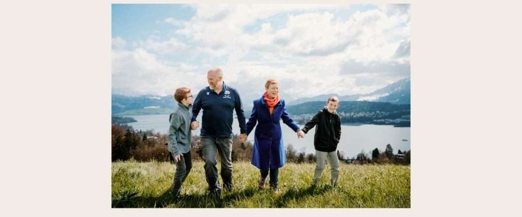Family walking together above Lake Lucerne with mountain views during a natural family photography session in Switzerland