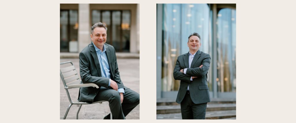Portrait of a confident business professional smiling in front of a sleek glass office. Relaxed business portrait of a man sitting on a chair in an open plaza.